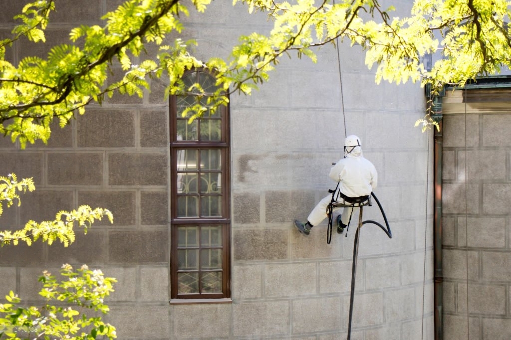 Cordiste professionnel réalisant un ravalement de façade